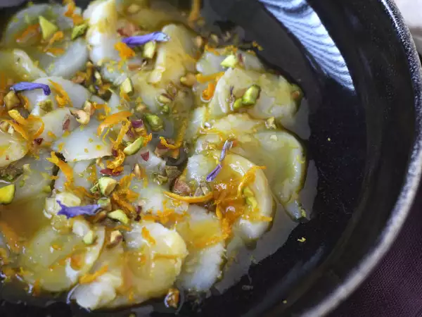 Receta Carpaccio de vieiras con vinagreta cítrica y pistachos, un entrante elegante y fácil de preparar