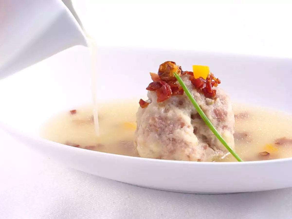 Albóndiga de cocido, rellena de setas, con crujiente de jamón y caldo de tuétano.