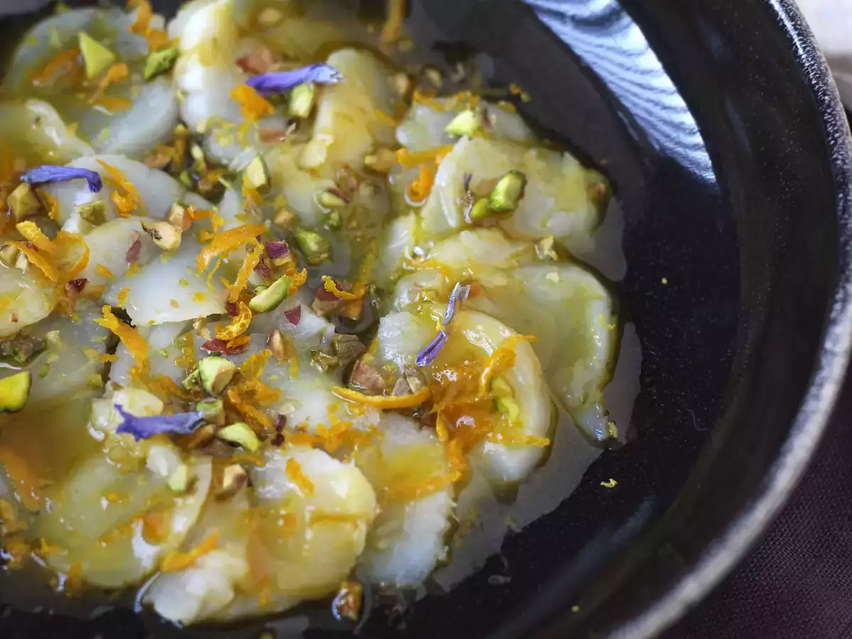 Carpaccio de vieiras con vinagreta cítrica y pistachos, un entrante elegante y fácil de preparar