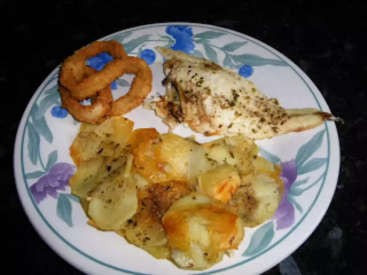 Dorada a la espalda sobre cama de patatas con calamares a la romana crujientes.