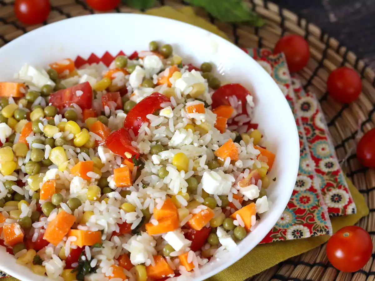 Ensalada de arroz vegetariana: maíz, queso feta, zanahorias, guisantes, tomate y menta