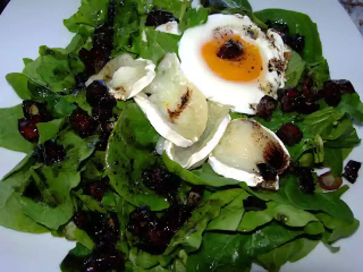 Ensalada templada de espinacas con queso de cabra, huevo y vinagreta de dátiles.