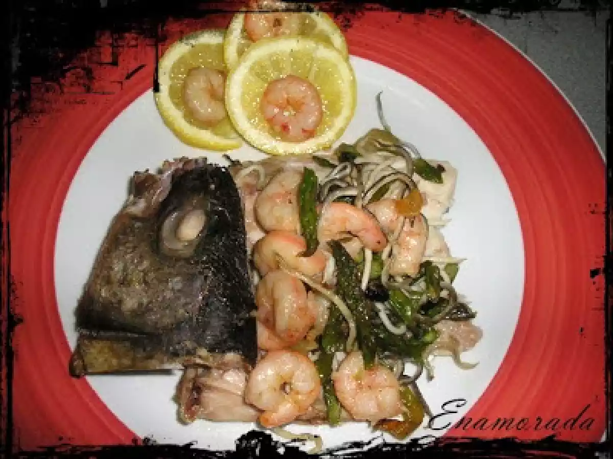 Lubina salvaje en cama de verduras cubierta de mar y tierra