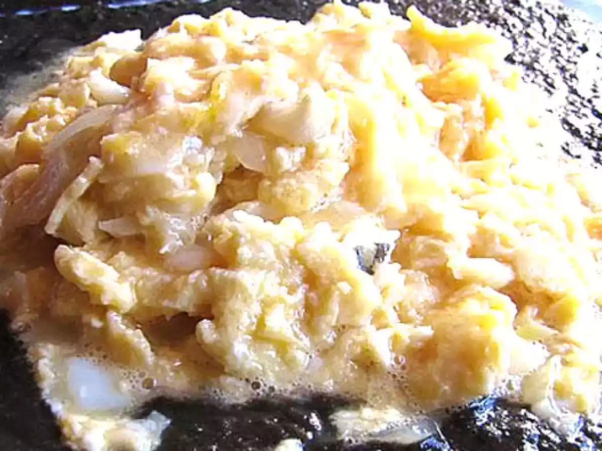 Revuelto de bacalao sobre salsa de tinta de calamar.